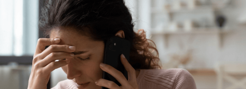 mujer frustrada por teléfono con un ajustador de la aseguradora de tu coche